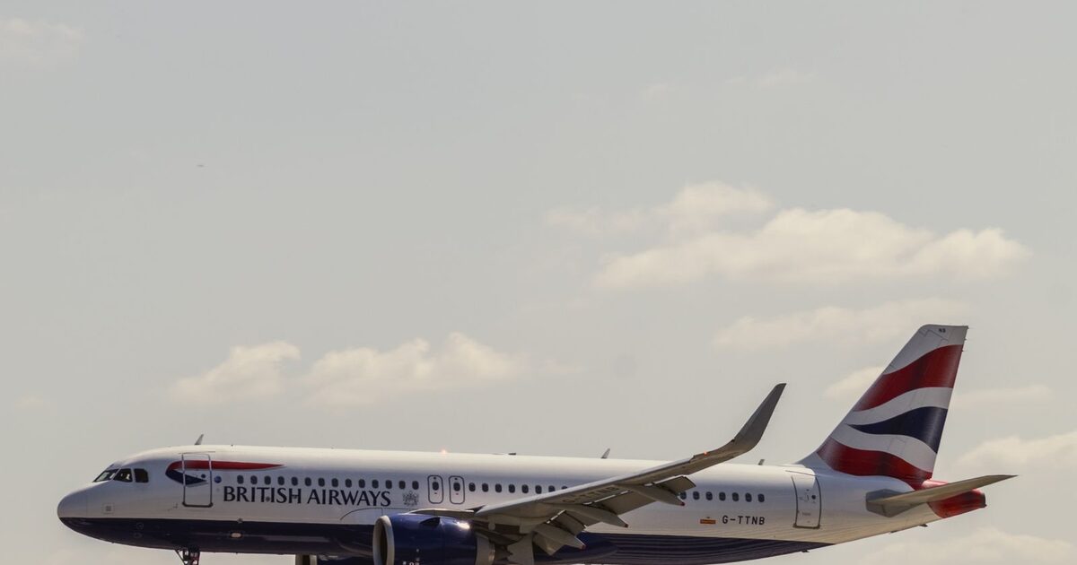 A British Airways aircraft coming in to land at Heathrow Airport, with terminal buildings and other aircraft visible below